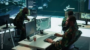 Military personnel in a high tech command center monitor satellite feeds, coordinate intelligence operations. Maintaining national security and supporting strategic army missions. Camera B.