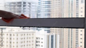 Washing windows. Home cleanliness care. Soap solution is splashed on the window. Clear glass. Scraper for cleaning windows. The housewife washes the window. Horizontal video. High quality 4k footage