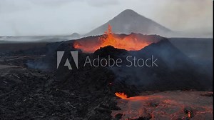Super slow-motion capture of an erupting volcano in Iceland, featuring lava explosions and molten rock flow, with smoke rising from the crater.