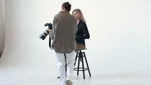 Professional photographer working with a beautiful model in a modern photo studio