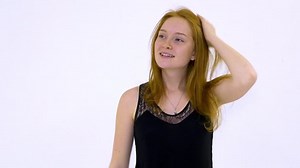 Young woman looking at camera while standing against white background
