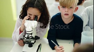 Group of kids students using microscope writing on notebook at laboratory classroom