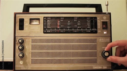 Carefully Tuning an Old Radio to Find the Perfect Station and Clear Frequencies