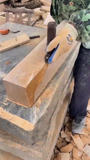 Worker shaping block on bench, tools nearby