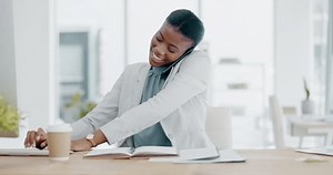 Black woman, phone call and writing in book consulting for financial advice, conversation or communication at office. Happy African female accountant talking on smartphone checking data on computer