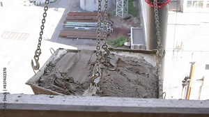 A detailed view of unclean construction buckets suspended at a construction site