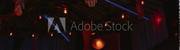 Grotesque severed body parts hanging from a dark ceiling in a spooky haunted house attraction, creating a creepy, macabre, and scary halloween horror scene with dimly lit bulbs