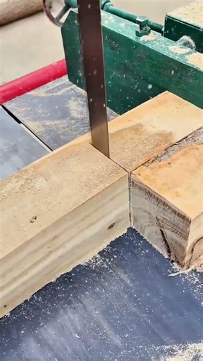 Cutting several large tree logs into wooden planks with a professional band saw machine