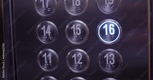Close-up, the finger of the hand presses the metal button of the elevator panel, the button is illuminated with blue lighting.