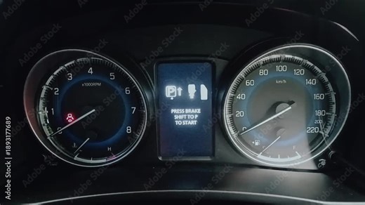 Illuminated car instrument cluster showing analog tachometer and speedometer with white markings, digital display clock and date, fuel and temperature gauges on dashboard.