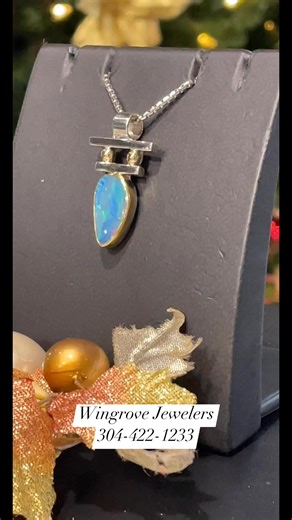 This handmade Native American pendant features luminous black opal set in sterling silver, accented with warm 18k gold details that highlight its natural fire. The piece reflects traditional craftsmanship, blending earthy elegance with refined artistry. | Wingrove Jewelers