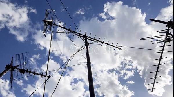 sky and clouds with television aerials in the foreground