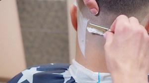 clip-1041885937-barber-shaving-clients-nape-open-razor-close