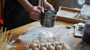 Sifting flour through sieve. Women hands sifting flour on a table. Cooking and backing preparation.