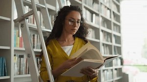 Latino Arabian woman librarian worker library ladder bookshelves textbooks knowledge education research turning pages holding book girl read bookworm reader teacher university learning study archive