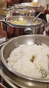 Elegant buffet presentation featuring white rice and stir-fried food options displayed in silverware