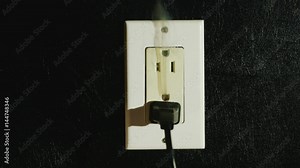 Fire in a dual-socket US type. Streams of black smoke come from the outlet. Danger to life and health