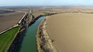 clip-1102873733-aerial-view-irrigation-canal-merging-river-flat