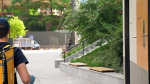 Delivery man wears protective medical face mask and gloves picks up paper bag lunch order at the supermarket restaurant deliver customer client. Food deliveryman worker employee with thermal backpack