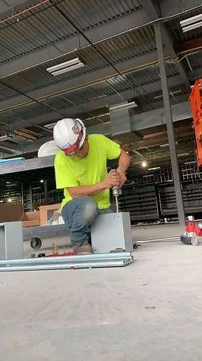 Electrician drilling and setting up pull boxes