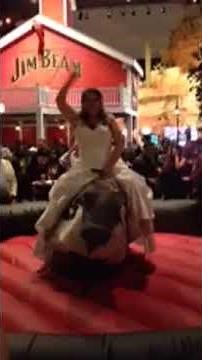 Bride rides mechanical bull in wedding gown