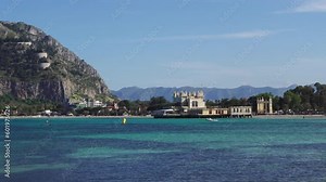Sicily, The Ancient Bathing Establishment in Mondello bay. Turquoise transparent blue sea water in the summer with and people paddleboarding. Vacation spot in Sicily, Palermo beach