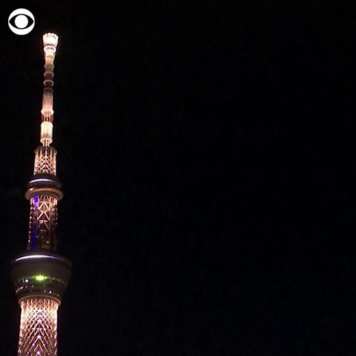 Tokyo Skytree, the tallest tower in the world, was illuminated on Tuesday in the pinkish gold hue of Tokyo's Olympic torch to mark the start of a 100-day tour of the Olympic flame. | CBS News