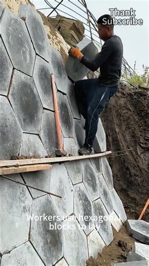 Workers use hexagonal blocks to pave the slope, making it stable and beautiful