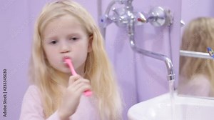 Happy blonde child kid girl laughing and brushing teeth with toothpaste. Health care, dental hygiene, people and beauty concept