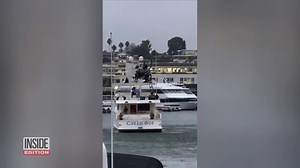 A military helicopter was seen hovering over a luxury yacht in Newport Beach, California. Two paratroopers with weapons drawn rappelled down and landed on the yacht. | Inside Edition