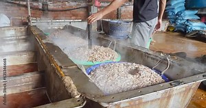 safety procedures when boiling shrimp in tanks. Worker makes a hole in the center to let out the heat