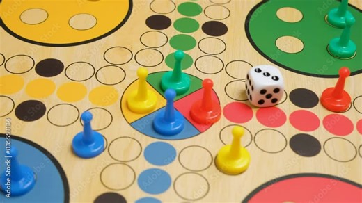 People play Ludo or Pachisi board game on beautiful wooden play board. Ludo is strategy board game for two to four players. 4K resolution family board game video.