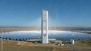 Aerial footage of a сoncentrated solar power station with a hollow tower. Modern or futuristic power plant. Solar farm center. Renewable energy concept.