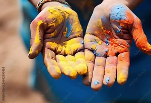Close-up of the hands of a child covered with bright paint