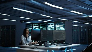 Engineer in data center installing software on computer, troubleshooting issues, handheld camera shot. IT professional in server hub establishing performance benchmarks, camera B