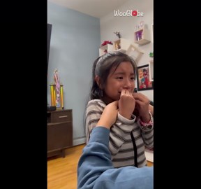 Little girl says goodbye to her loose tooth with a touch of sisterly love