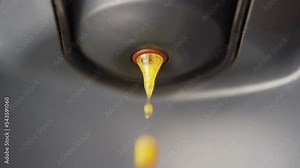 Coffee slowly coming out of a capsule coffee machine in a slowmotion shot.