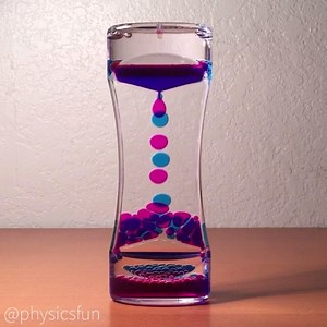 Oil Drop Timer http://physicstoys.blogspot.com/p/physics-toy-store.html Immiscible liquids, in two containers of colored oil and kerosine in this case. The oil in each container falls through a small drop forming hole in between clear walls of acrylic. Note how surface tension forms the smaller drops into nearly perfect circles and limits the size of the drop formation. In addition the drops fall at terminal velocity with smaller drops falling faster than larger ones. ➡️ Follow the link above fo