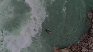 A rescuer crossing the river with the method of Tyrolean traverse. This is used in a range of mountaineering activities: rock climbing , tree climbing, caving, water crossings and mountain rescue.