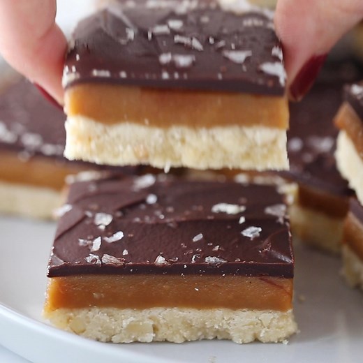 Recipe: https://www.recipegirl.com/millionaire-shortbread/ Millionaire Shortbread is a sweet treat that originated in Scotland. In these bars, there are three layers of buttery shortbread, gooey caramel and rich chocolate. Flaky sea salt is sprinkled on top! | RecipeGirl