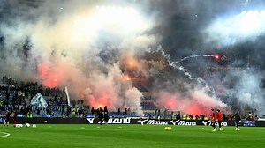 Roma star hit with bottle as fans launch flares at each other during derby