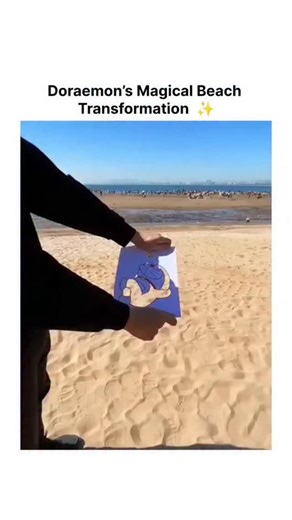 ELITE BALL🥸 on Instagram: "The post shares a 10-second video of an anamorphic beach illusion: a held paper drawing of Doraemon starts as a shadow silhouette against the sun, then reveals vibrant colors and a butterfly, synced to the nostalgic Doraemon opening lyrics evoking dreams and wishes. Created by Japanese user @tannokasa3 , who specializes in fun and unusual videos, the content taps into Doraemon's cultural icon status—a 1969 manga character symbolizing childhood ingenuity—driving rapid