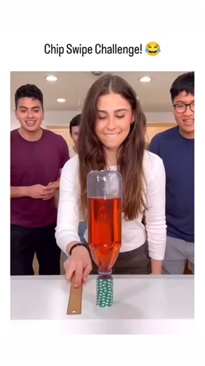 FUNNY OPPS CLIPS on Instagram: "The post features a 19-second video of a group of friends in a kitchen attempting the "Chip Swipe Challenge," where they use a wooden ruler to knock a stack of green poker chips off a stick balanced atop a bottle of red liquid, succeeding without spilling it amid laughter and cheers. Posted on November 16, 2025, by Indonesian user @TenangTweet , the clip quickly amassed 265,000 views, 226 likes, and 33 replies praising its fun and relatable vibe, reflecting viral 