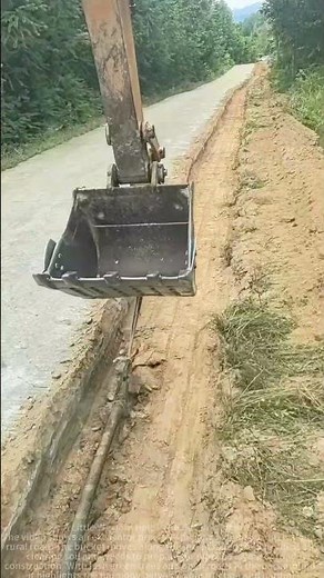 Excavator Precision Digging Drainage Ditch Along Scenic Roadside**