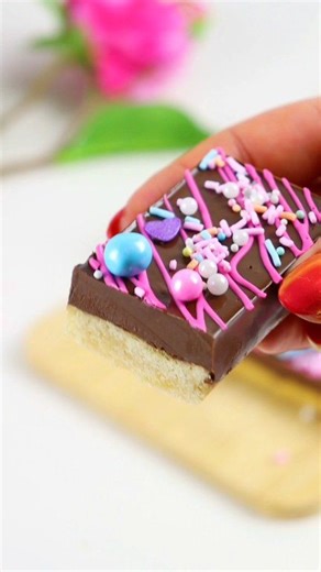 Shortbread nutella ganache bars 😋 Use shortbread cookie dough to fill the molds half way up and bake. Combine equal parts melted nutella spread with dark chocolate and pour over the shortbread. Decorate with a chocolate drizzle and sprinkles. Set and serve! Tools linked to my amazon storefront-link in bio and comments #shortbread #valentinestreats #cookiebars #treatmaker #cookiedecorating | Loveisbakeable