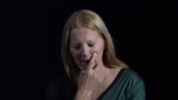 Thoughtful senior woman looking down with hand on chin. Close-up of...