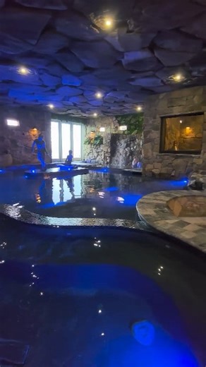 Pool and Speakeasy under the house. We designed and built this Insane Pool and Speakeasy, with lots of seating for parties, a huge spa, natural rock waterfalls, 48 tons of rock suspended above your head, a custom bronze sculpture capturing the Client's kids in their childhood glory at the beach, and 1920’s décor for the speakeasy. #speakeasy #insanepools #lucaslagoons #insane #poolbuilder #mancave | Lucas Lagoons