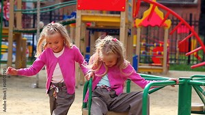 Little girl turning her sister on carousel