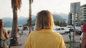 Back View, Woman Walking, happy young tourist woman relaxing in park. Female model breathing fresh air outdoors, walking and dancing, Healthy active concept.