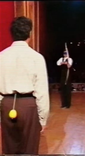 The performer stands far away, wearing a blindfold-style eye cover, holding a bow with an arrow, fully focused......This video is generated using ai for educational and entertainment purpose | Brainy Dose